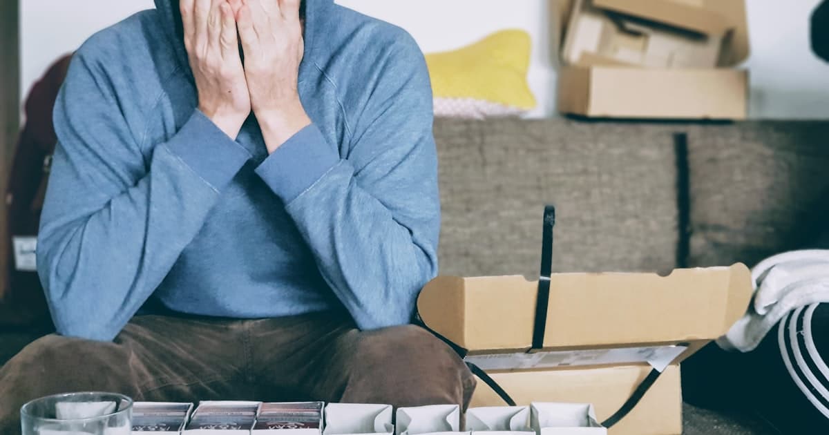 Man sitting on steps with his head in his hands, overwhelmed